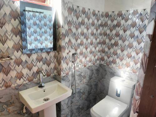 a bathroom with a white toilet and a sink at Dobhanay Homestay in Simāna Basti