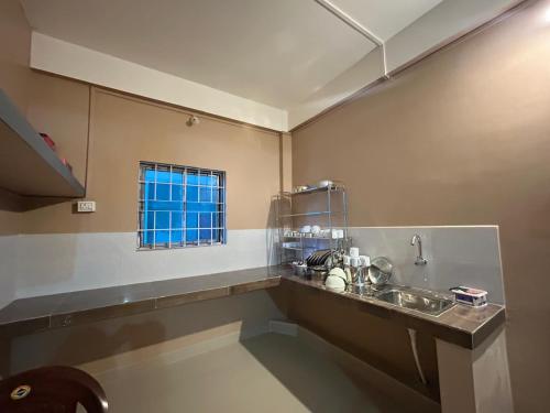 a kitchen with a sink and a window at Aika Homestay in Pāsighāt