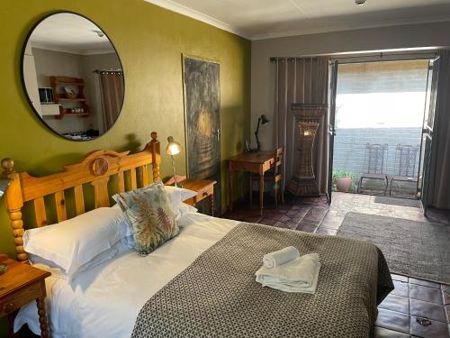 a bedroom with a large bed with a mirror at Dias Guest House in Bloemfontein