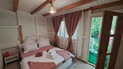 a bedroom with a bed with two stuffed animals on it at Căsuța Veselă in Tătuleşti