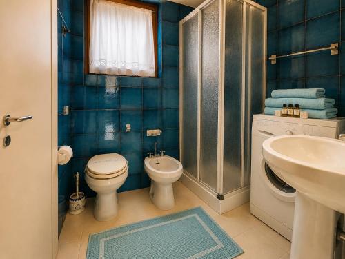a bathroom with a toilet and a sink at Amazing Sea View Terrace A with Pool 70m from the Beach in Baja Sardinia