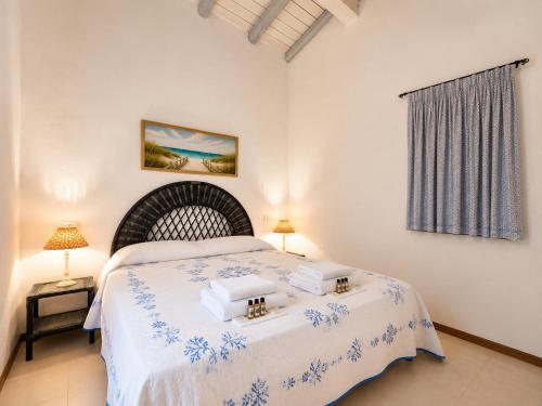 a bedroom with a bed with towels on it at Amazing Sea View Terrace A with Pool 70m from the Beach in Baja Sardinia