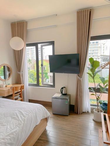 a bedroom with a bed and a flat screen tv at Glory 2 Hue Homestay in Hue