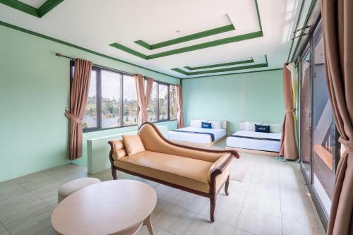 a room with two beds and a couch and a table at Villa Malakai By ARBA in Palayangan