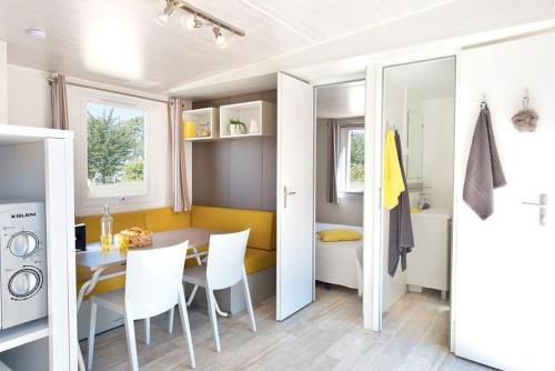 a kitchen with a table, chairs and a refrigerator at Giannella Camping in Orbetello