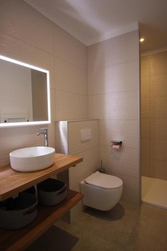 a bathroom with a sink and a toilet and a mirror at Villa d exception piscine privée 200m2 10 pers RESTONICA Les Terrasses de Ruppione in Pietrosella