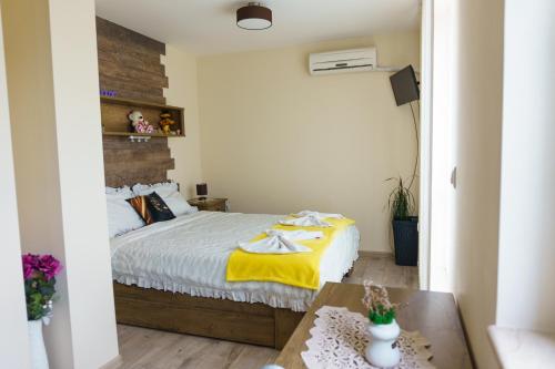 a bedroom with a bed with a yellow blanket on it at Desitas home in Plovdiv