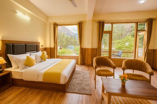 a hotel room with a bed and a large window at Hotel The Winterline - Best Selling Property in Kasol 2025-26 in Kasol