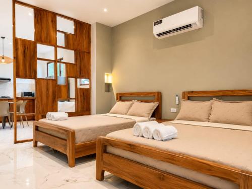 a bedroom with two beds and a air conditioner on the wall at Islander Suite in Puerto Baquerizo Moreno