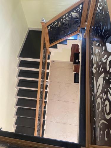 a spiral staircase with black and white railing at Coz Rooms in Varkala