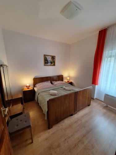 a bedroom with a large bed and a red curtain at Aranymoha Vendégház in Szőce
