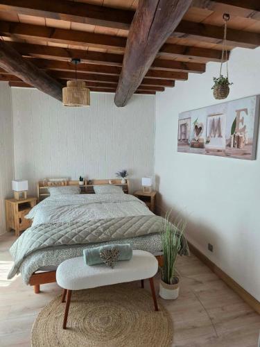 a bedroom with a large bed and a table at La Maison Delle Spellé - Meublé de Tourisme 4 étoiles in Piolenc