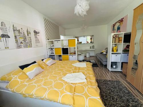 a bedroom with a large yellow bed in a room at Apartment city centrum in Nitra