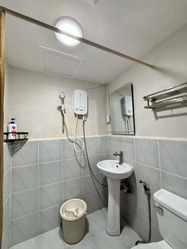 a bathroom with a sink and a toilet and a mirror at Pinili Homestay in Suba