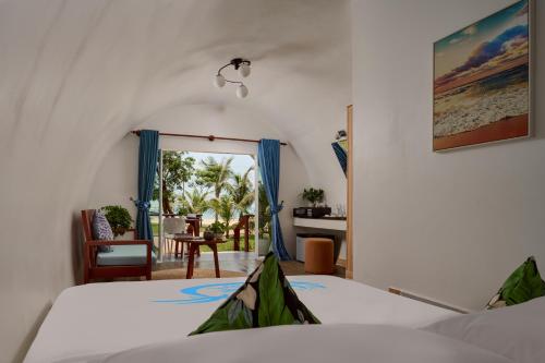 a bedroom with a bed and a view of the ocean at Tube Resort by EHM in Koh Rong Sanloem