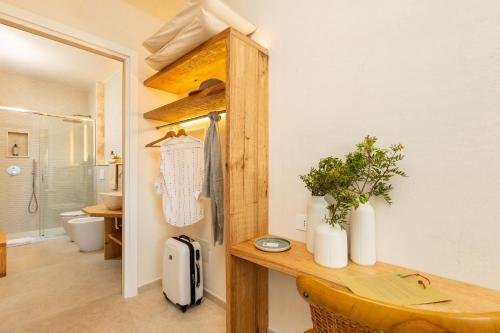 a room with a desk and a bathroom with a shower at Marinaio di foresta Bedroom in Baunei