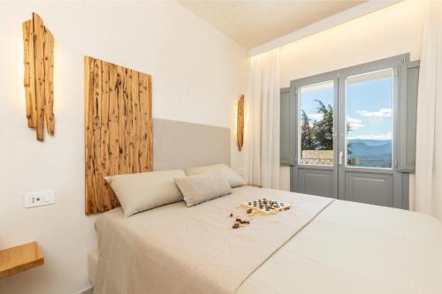 a bedroom with a large white bed with a window at Marinaio di foresta Bedroom in Baunei