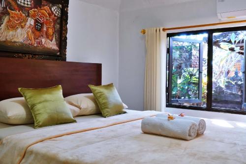 a bedroom with a large bed with a large window at Tegeg's Homestay in Keramas