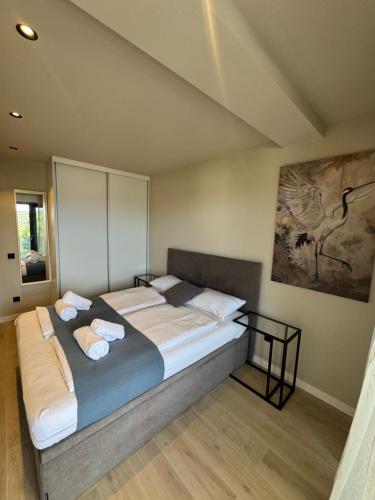 a bedroom with a large bed with a painting on the wall at Vila Marila in Stara Novalja