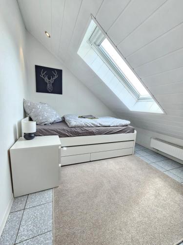 ein Dachgeschoss-Schlafzimmer mit einem Bett mit Dachfenster in der Unterkunft FeWo Sundernblick in Haltern