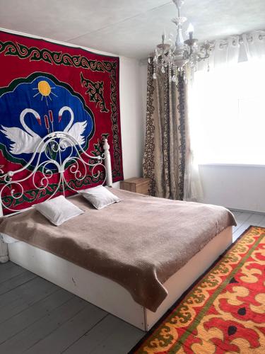 a bedroom with a bed with a red and blue headboard at Nomad place - horse riding tour Son-Kul in Dzhangyaryk