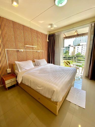 a bedroom with a large bed and a large window at De Chalet in Bangkok