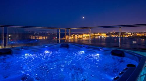 a jacuzzi tub on a balcony at night at Valletta Luxury 4-Bedroom Duplex with Stunning Sea Views Private Terrace and Jacuzzi in Valletta
