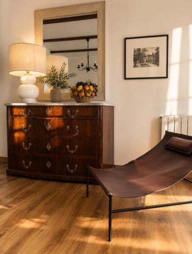 a chair in a room with a dresser and a mirror at ComeCasa Langhe Garden House-Pace e Panorama a Benevello in Benevello