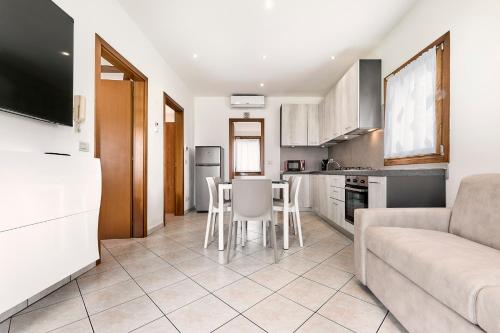 a kitchen and living room with a couch and a table at Eden Beach House - Host Solution in Cavallino-Treporti