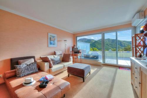 a living room with a couch and a large window at Panorama Maggiore Apartment with Pool in Locarno - Happy Rentals in Locarno