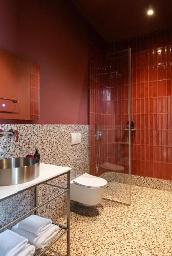 a bathroom with a shower and a toilet and a sink at FOS Luxury Suites in Nikiti