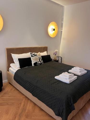 a bedroom with a large bed with towels on it at Opal Villa in Băile Tuşnad