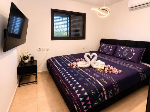 a bedroom with a bed with two swans on it at Olympus B&B in Mitzpe Ramon
