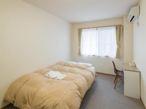 a bedroom with a bed and a desk and a window at Hotel Morimotoya 板野店 in Kamiita