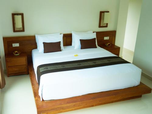 a bedroom with a large bed with white sheets at Eden House Ubud in Ubud