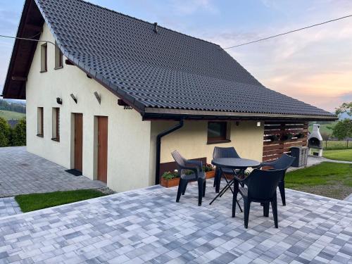 a patio with chairs and a table in front of a house at Domki pod Beskidem in Jaworzynka