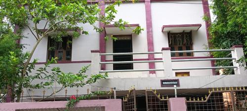 a white building with a fence in front of it at Aiswarya illam in Chidambaram