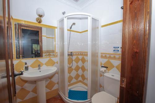 a bathroom with a shower and a sink and a toilet at Casa Teones con piscina privada in Montecorto