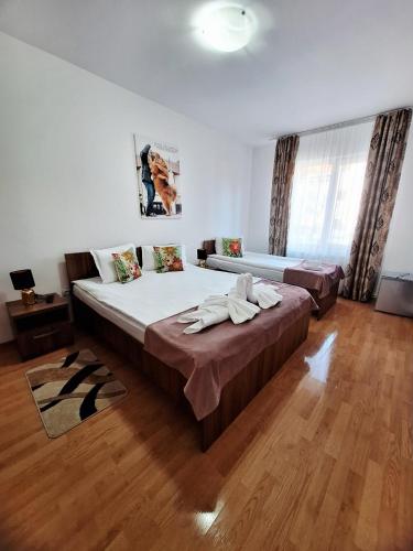 a large bedroom with a large bed and wooden floors at Thor și Cora in Sovata
