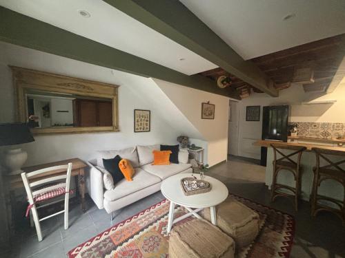 a living room with a white couch and a table at Gîte casa cosy in Salies-de-Béarn