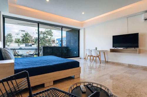 a bedroom with a large bed and a television at Beautiful apartment Top location! in Playa del Carmen