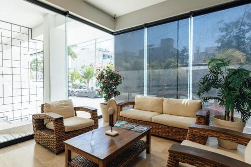 a living room with a couch and chairs and a table at Beautiful apartment Top location! in Playa del Carmen