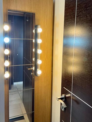 a bathroom with a glass shower door with lights at Elia in Ptolemaida