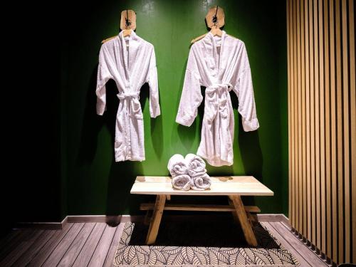a table with three robes hanging on a green wall at Domaine de la Jarrige in Saint-Vaury
