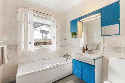 a bathroom with a white tub and a sink and a tubermottermott at Reine Panorama in Reine