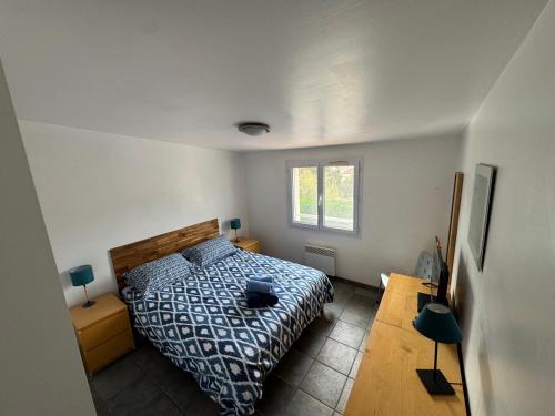 a bedroom with a bed and a table and a window at Le Pavot in La Tranche-sur-Mer