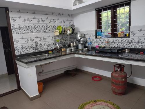 a kitchen with a sink and a counter top at Grace villa Homestay in Vattavada