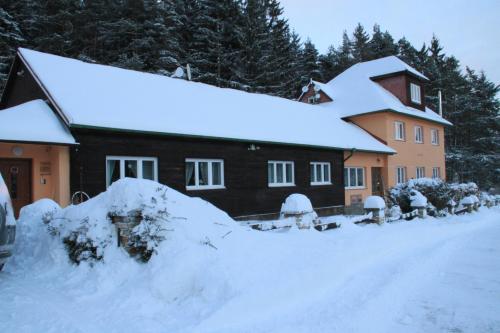a house with a pile of snow in front of it at Chata Javorina in Javorník