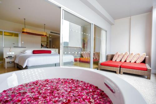 a bathroom with a tub filled with pink flowers at Ramada by Wyndham Phuket Deevana in Patong Beach