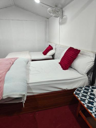 a bedroom with two beds with red and white pillows at Newari chulo ghar in Bhaktapur